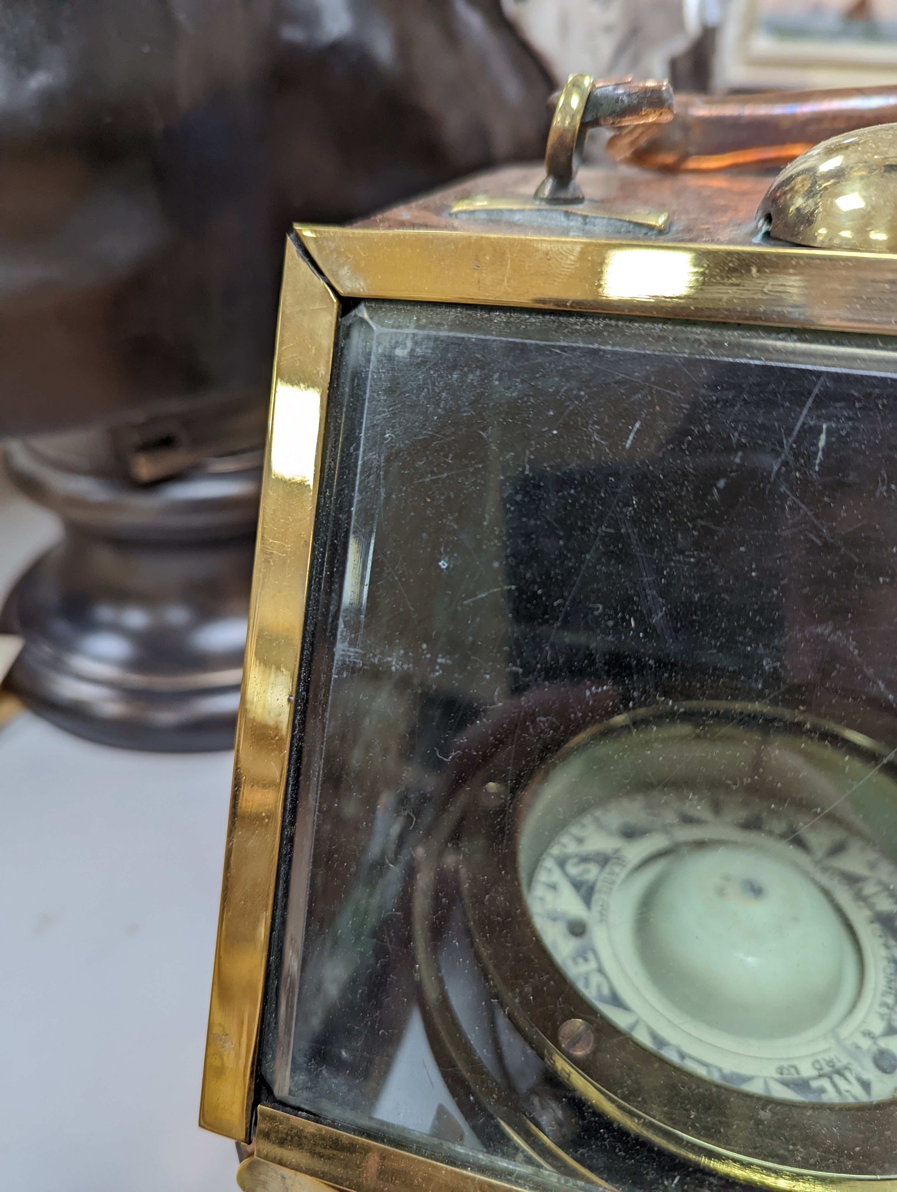 A copper ship's binnacle compass, a brass oil lamp, a brass jug and a copper kettle